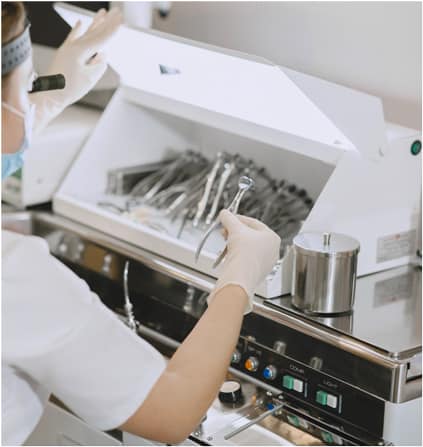 A nurse sterlizing the dental kits in autoclave  sterlizing machine at 4 square dentistry