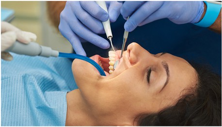 Dentist using tools on patient lady patient to treat Gingivitis  at 4SquareDentistry