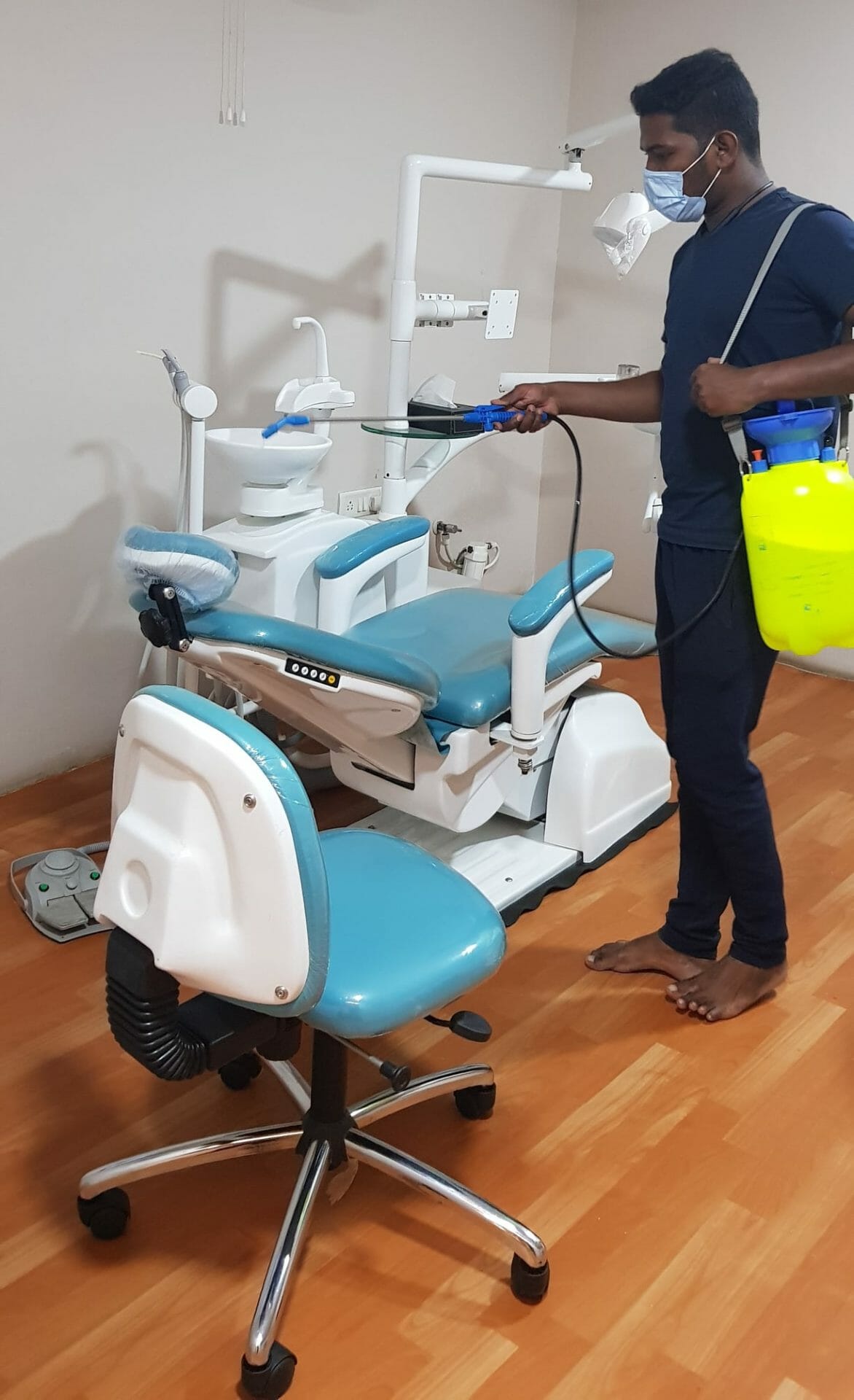 A sanitation worker cleaning dental equipment in the 4Squares dental clinic in medavakkam